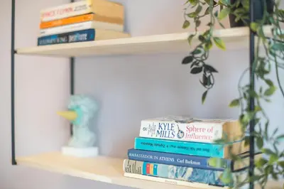 a stack of books sitting on a shelf at Studio Under Acropolis Rock in Athens
