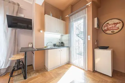 a kitchen with a desk and a sink and a window at Studio Under Acropolis Rock in Athens
