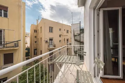 a balcony with two benches and a view of buildings at Studio Under Acropolis Rock in Athens