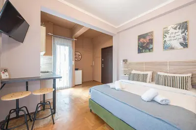 a bedroom with a bed and a table and a television at Studio Under Acropolis Rock in Athens