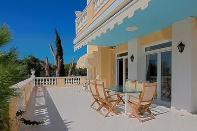 a patio with a glass table and chairs at Villa Emily in Lagonissi
