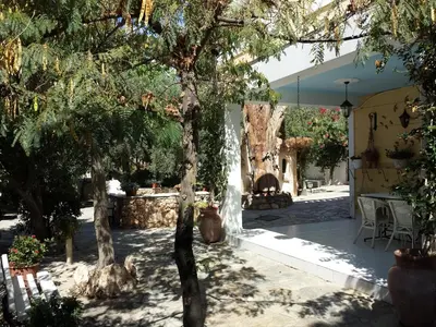 a courtyard with trees and a table and a fireplace at Villa Emily in Lagonissi