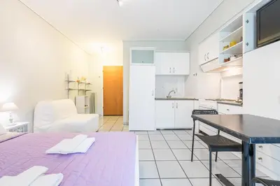 a kitchen and living room with a table and chairs at Zenios Kisamos-Pretty comfy studio in Athens