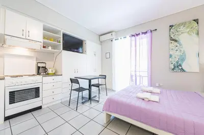 a bedroom with a purple bed and a table and chairs at Zenios Kisamos-Pretty comfy studio in Athens