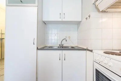 a kitchen with white cabinets and a sink at Zenios Kisamos-Pretty comfy studio in Athens