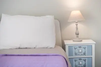 a bedroom with a bed with a lamp on a night stand at Zenios Kisamos-Pretty comfy studio in Athens