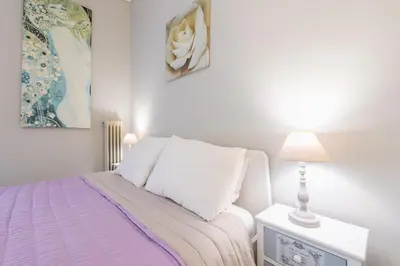 a white bedroom with a bed and a lamp at Zenios Kisamos-Pretty comfy studio in Athens