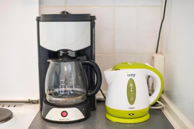 a blender and a coffee maker on a counter at Zenios Kisamos-Pretty comfy studio in Athens