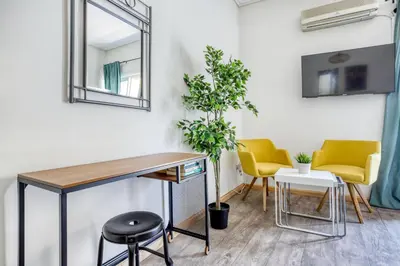 a desk in a room with two chairs and a mirror at Studio in The Heart of Acropolis in Athens