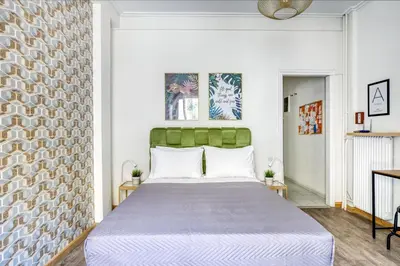 a bedroom with a large bed with a green headboard at Studio in The Heart of Acropolis in Athens