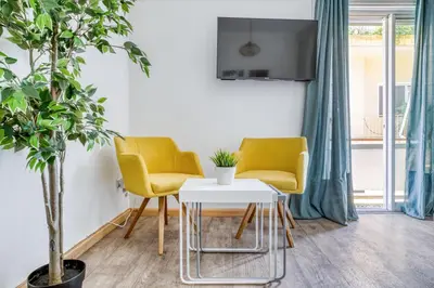 two yellow chairs and a white table in a room at Studio in The Heart of Acropolis in Athens