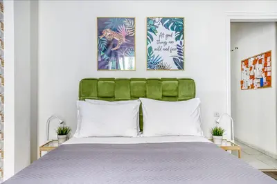 a bedroom with a bed with a green headboard at Studio in The Heart of Acropolis in Athens