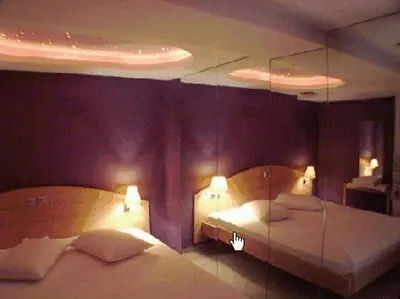 a bedroom with two beds and two lamps in it at Hotel Niki Piraeus in Piraeus