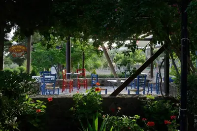 a group of chairs and tables in a garden at Vagia Traditional, Aegina Island in Vaia