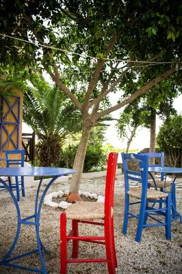 three chairs and a table and a table and chairs at Vagia Traditional, Aegina Island in Vaia