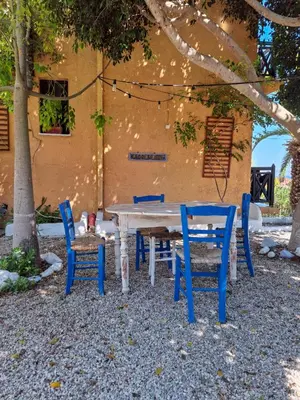 a picnic table and chairs in front of a building at Vagia Traditional, Aegina Island in Vaia