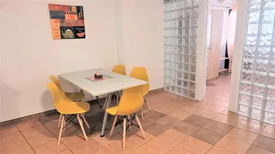 a dining room with a white table and yellow chairs at Driopon Apartment in Athens