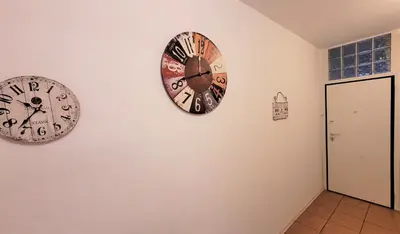 two clocks on the wall in a room at Driopon Apartment in Athens