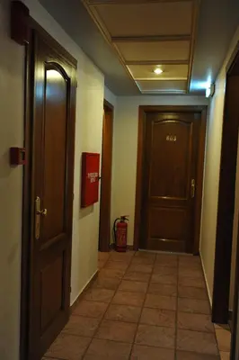 an empty hallway with a door and a tile floor at Hotel Katerina in Athens