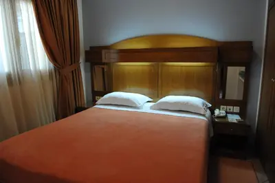 a bedroom with a large bed with a wooden headboard at Hotel Katerina in Athens
