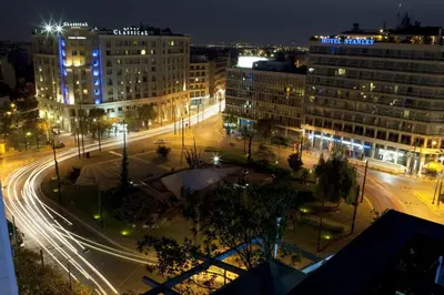 a city street at night with buildings and street lights at Hotel Katerina in Athens