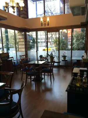 a dining room with tables and chairs and windows at Hotel Katerina in Athens