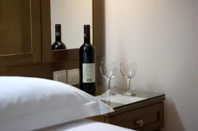 a bottle of wine and two wine glasses on a table at Hotel Katerina in Athens