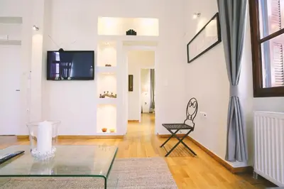 a living room with a glass table and a chair at Central Apartments in Psiri - Athens in Athens