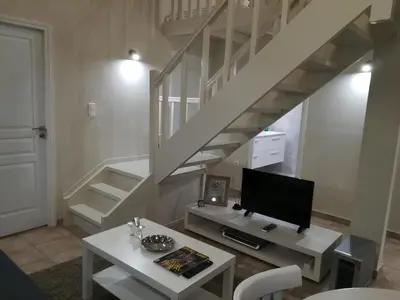a living room with a tv and a staircase at Central Apartments in Psiri - Athens in Athens