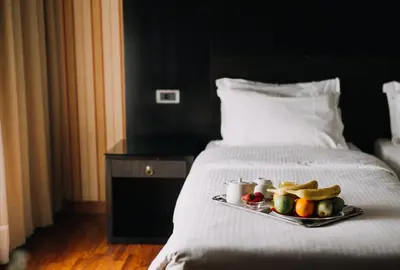 a tray of fruit on a bed in a hotel room at Areos in Athens
