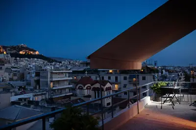 a view of a city at night from a balcony at Areos in Athens
