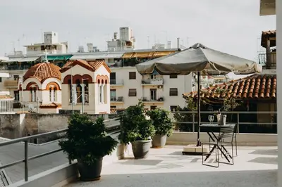 a patio with a table and an umbrella on a roof at Areos in Athens