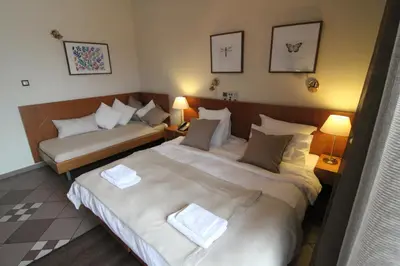 a hotel room with two beds and two lamps at Achillion Hotel in Athens