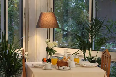 a table with a white table cloth and a lamp at Achillion Hotel in Athens
