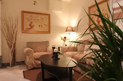 a living room with a couch and a chair and a table at Achillion Hotel in Athens