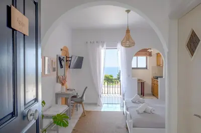 a living room with an archway leading to a kitchen at Pefkides Aegina Boutique Apartments in Agia Marina Aegina
