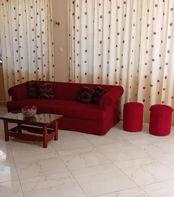 a living room with a red couch and a table at Hermes in Agia Marina Aegina