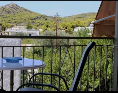 a table and chairs on a balcony with a view at Hermes in Agia Marina Aegina