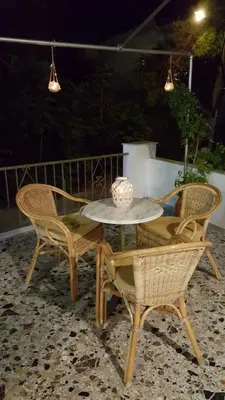 a table and chairs on a patio at night at Hermes in Agia Marina Aegina