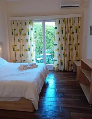 a bedroom with a bed and a large window at Hermes in Agia Marina Aegina