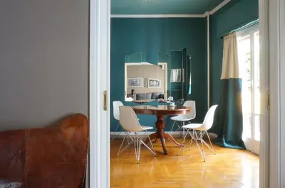 a dining room with a table and white chairs at The Belgian Connection in Koukaki in Athens