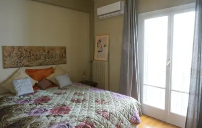a bedroom with a bed and a large window at The Belgian Connection in Koukaki in Athens
