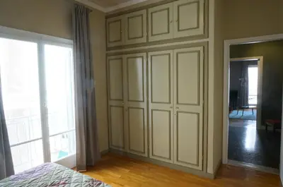 a bedroom with a large white cabinet and a window at The Belgian Connection in Koukaki in Athens