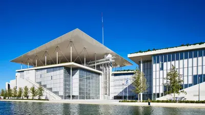 a large white building with a large glass facade at The Belgian Connection in Koukaki in Athens