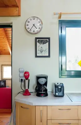 a kitchen counter with a clock on a wall at Olive Grove in Anavissos