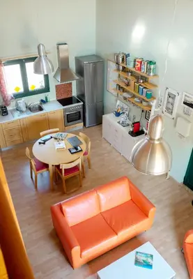 a living room with an orange couch and a table at Olive Grove in Anavissos