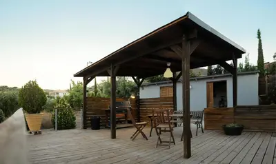 a pavilion with chairs and a table on a wooden deck at Olive Grove in Anavissos