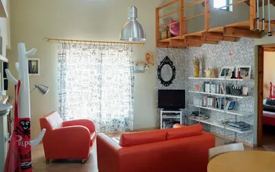 a living room with a red couch and a window at Olive Grove in Anavissos