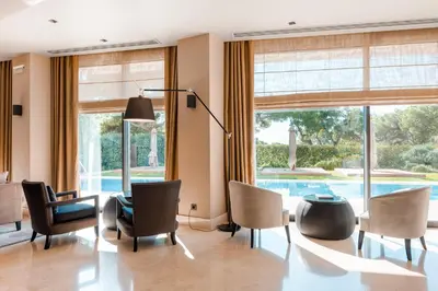 a living room with a pool seen through the windows at Somewhere Vouliagmeni in Athens
