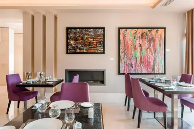 a restaurant with purple chairs and tables and a fireplace at Somewhere Vouliagmeni in Athens